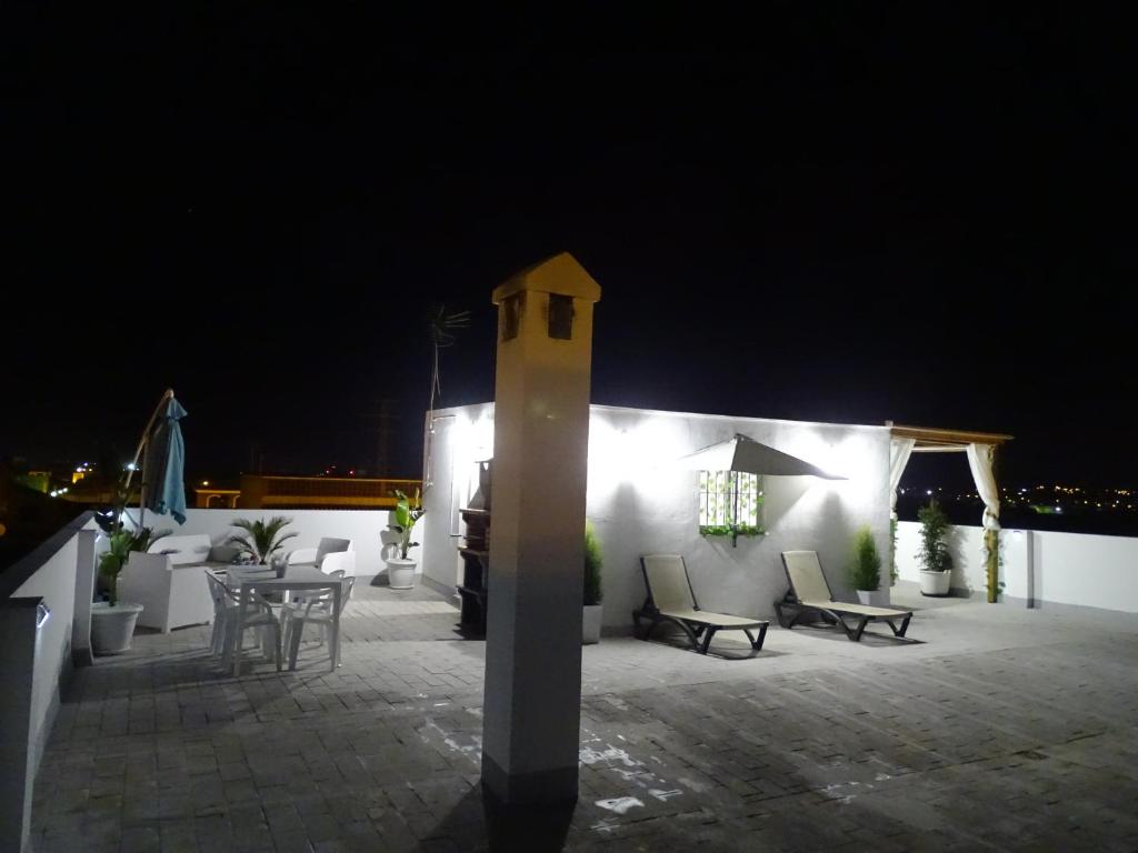 a patio at night with a table and chairs at Casasjerezanas VistaFlor in Jerez de la Frontera