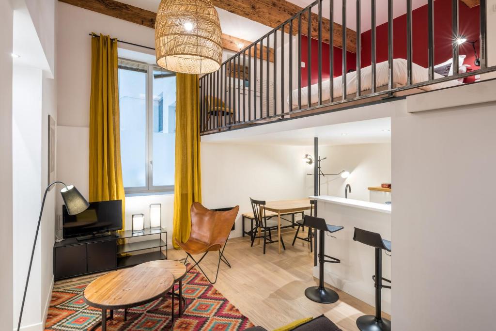 uma sala de estar com uma escada e uma mesa em Honorê - Suite Vaubecour em Lyon