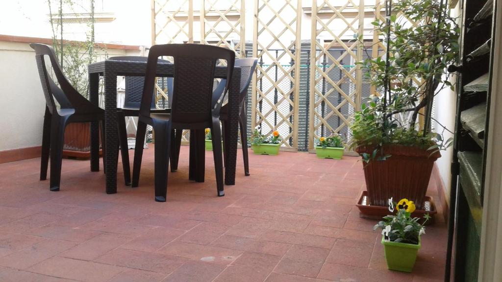 a table and chairs on a patio with potted plants at Terrazza Giraldi in Florence