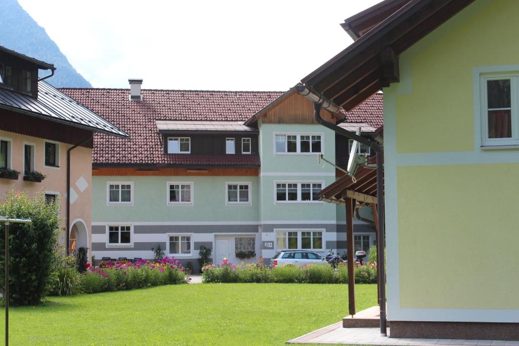 a large house with a car parked in a yard at Ferienhof Osl in Obertraun