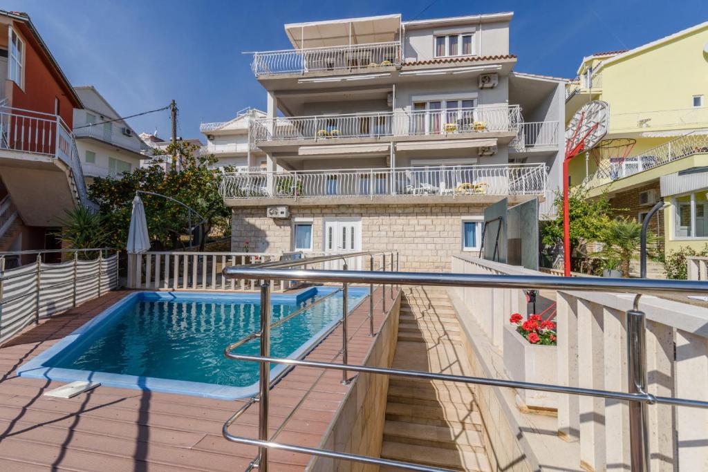 um apartamento com uma piscina em frente a um edifício em La Bodega Apartments em Trogir