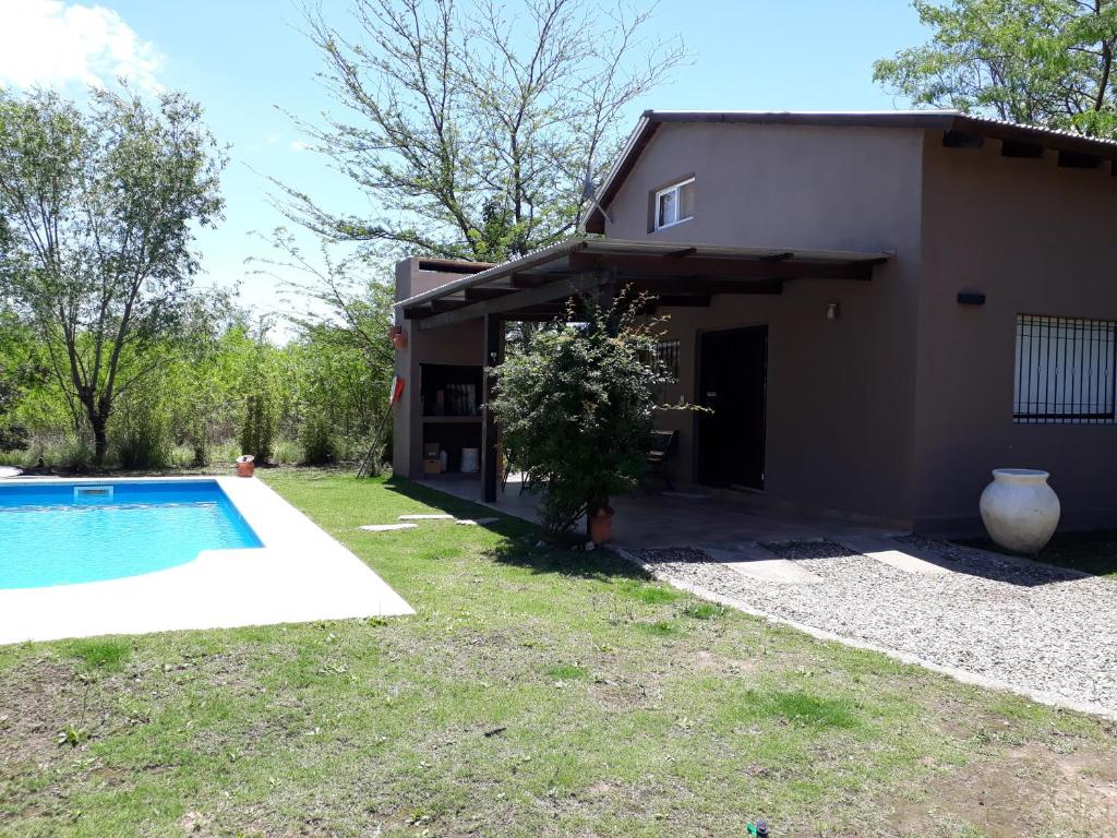 una casa con piscina frente a ella en Cabaña Josefina en Los Reartes