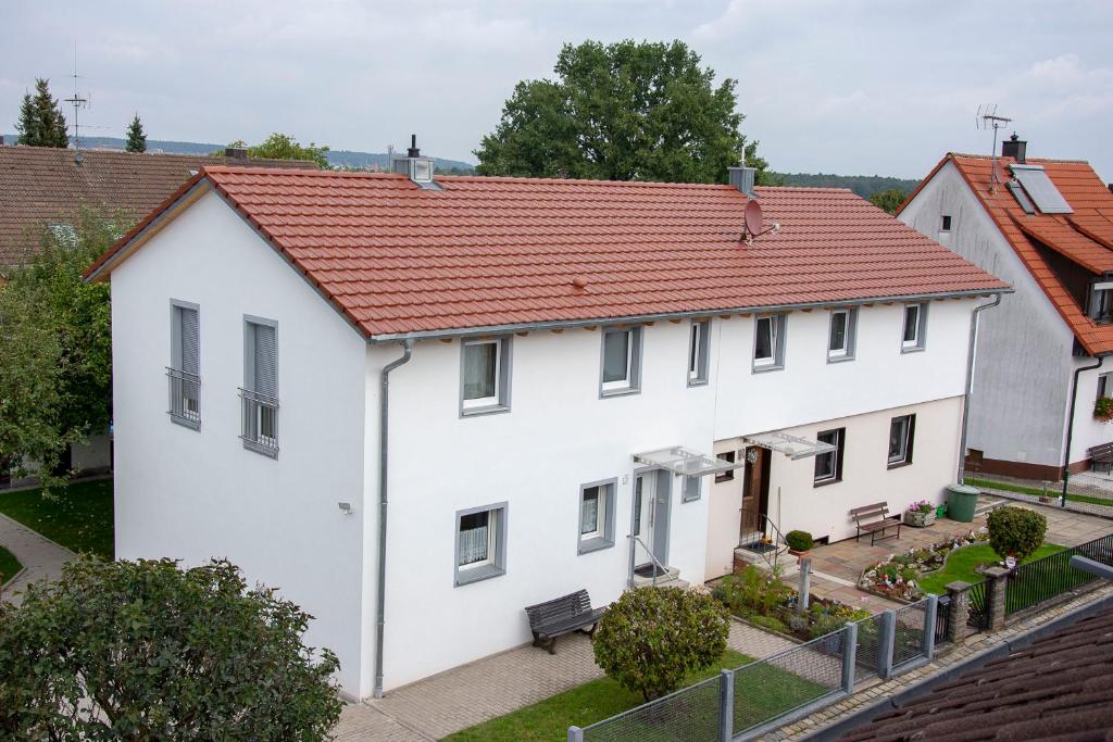 widok na biały dom z czerwonym dachem w obiekcie Appartment Vogel Ferienwohnungen w mieście Zirndorf