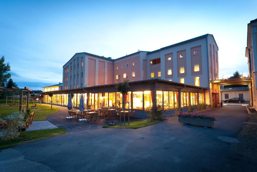 budynek ze stołami i krzesłami przed nim w obiekcie JUFA Hotel Weinviertel - Eselsmühle w mieście Seefeld