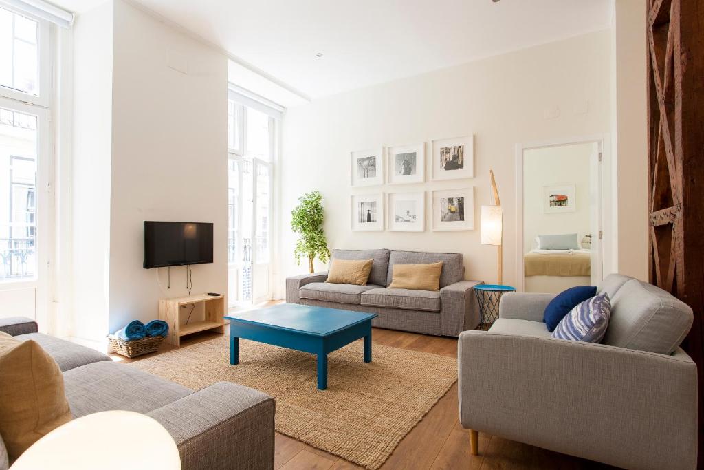 ein Wohnzimmer mit 2 Sofas und einem TV in der Unterkunft Central Downtown by Central Hill Apartments in Lissabon