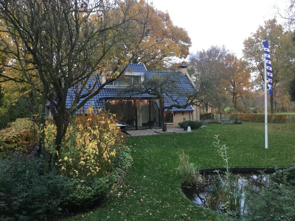una casa en un patio con un estanque en De Fugelsang en Jonkersland
