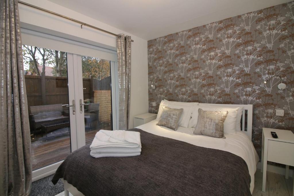 - une chambre avec un lit et une porte coulissante en verre dans l'établissement Sweet Suites Residence, à Lytham St Annes