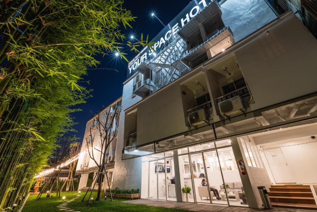 a facade of a building at night with lights at Your Space Hotel Prasingh in Chiang Mai