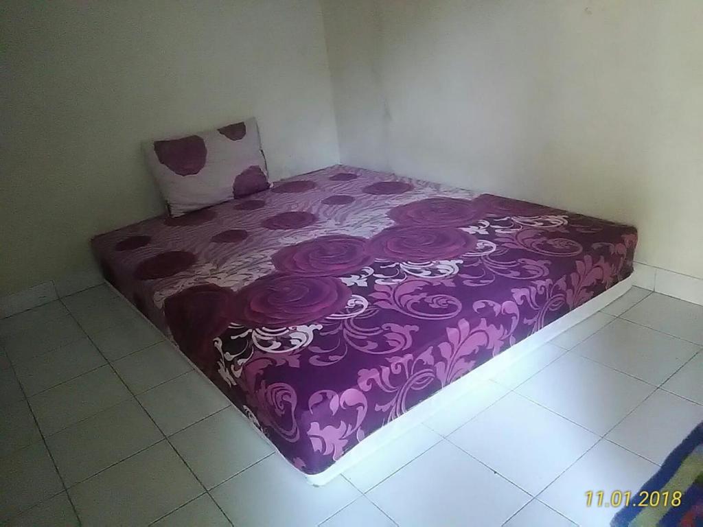 een paars bed in een hoek van een kamer bij Janti Transit Room Syariah in Yogyakarta