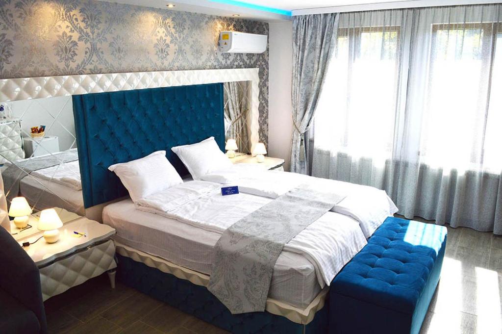 een slaapkamer met een groot bed met een blauw hoofdeinde bij Arbanasi DELUXE Villa in Arbanasi