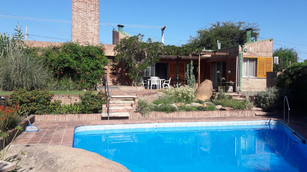 una casa con piscina frente a una casa en Homero y Martín Coronado en Villa Carlos Paz