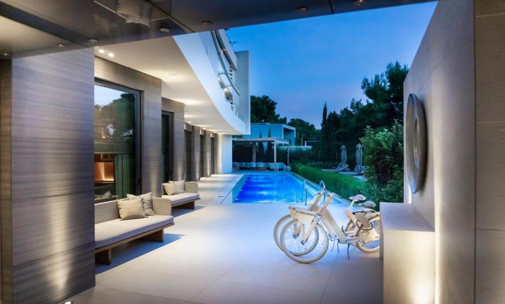 a house with a motorcycle in the middle of a yard at Somewhere Vouliagmeni in Athens