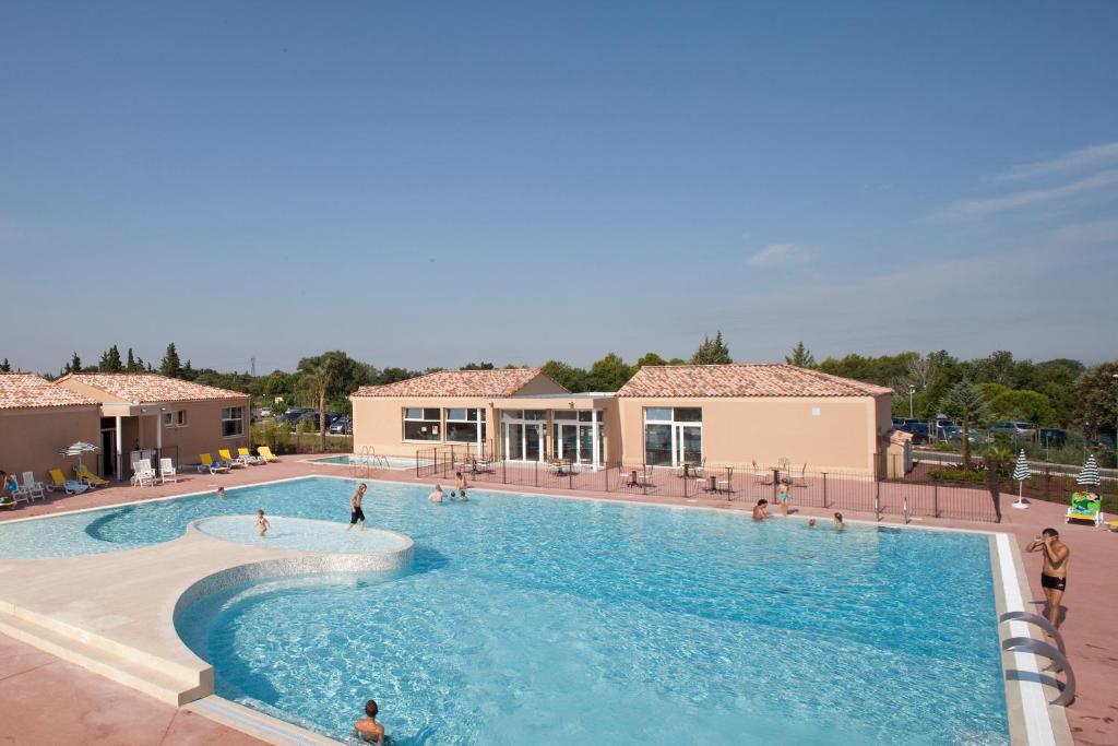 - une piscine dans un complexe avec des personnes dans l'établissement Vacanceole - Residence les Demeures du Ventoux, à Aubignan