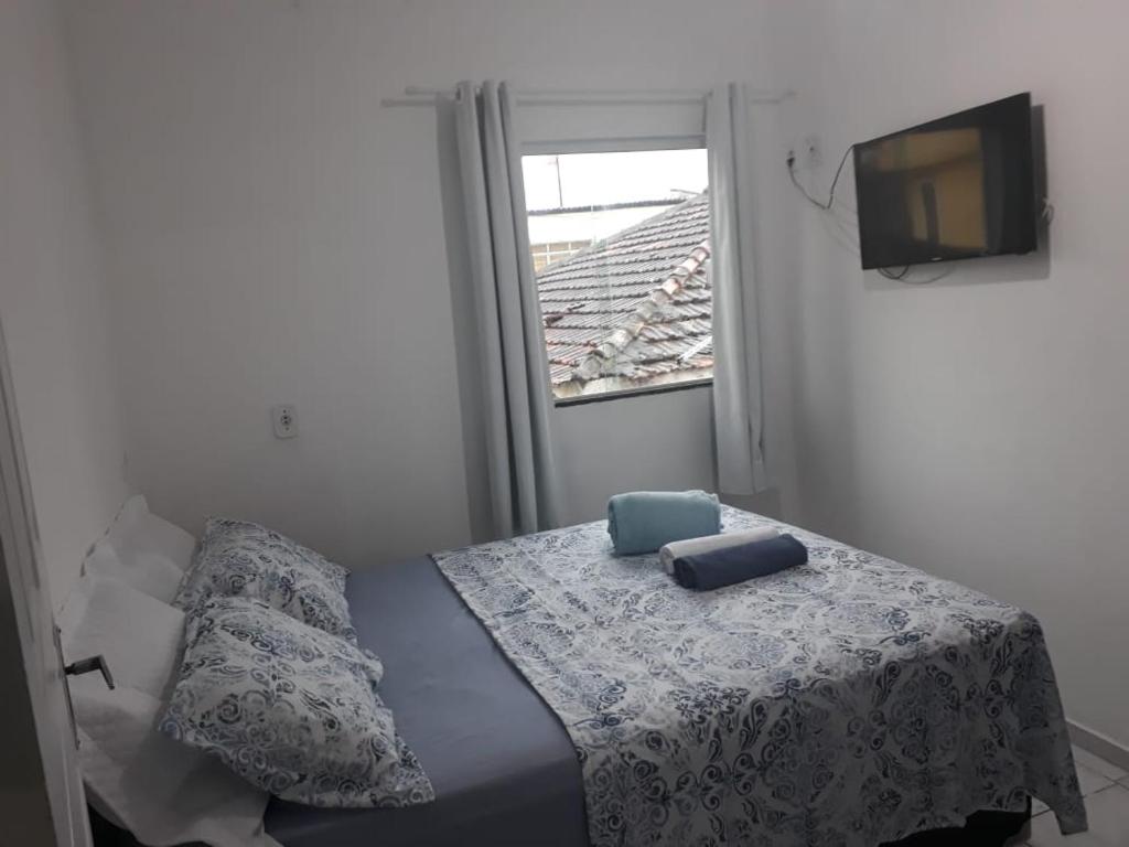 a bedroom with a bed and a window and a television at Arraial Sobradinho in Arraial do Cabo