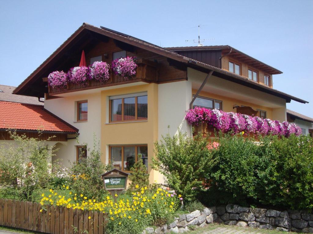 uma casa com flores ao lado dela em Ferienwohnung Schlossberg em Hopferau