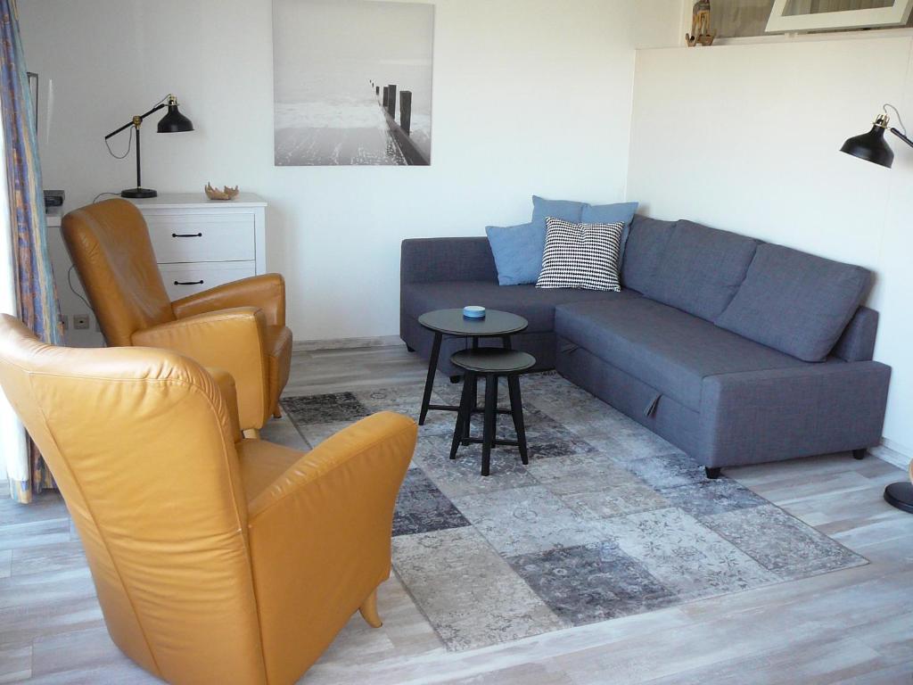 a living room with a couch and a table and chairs at Strandslag Zanddijk 229 Julianadorp aan Zee in Julianadorp
