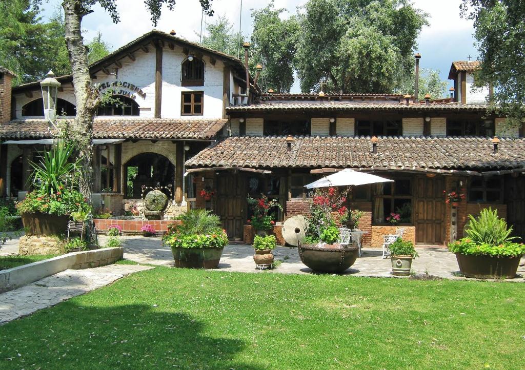 a large house with a garden in front of it at Hotel Hacienda Don Juan in San Cristóbal de Las Casas
