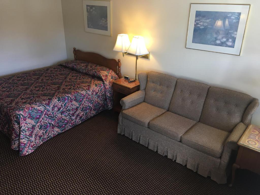 ベニントンにあるCatamount Motelのベッドとソファ付きのホテルルーム
