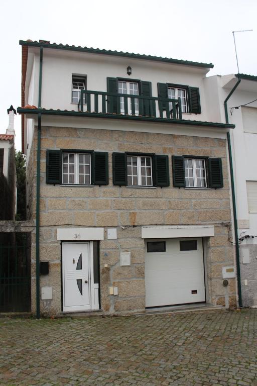 un gran edificio de ladrillo con dos puertas blancas de garaje en Casa do Adro en Arcozelo