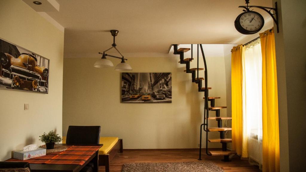 a living room with a spiral staircase and a clock at Velvet Lazienki Park in Warsaw