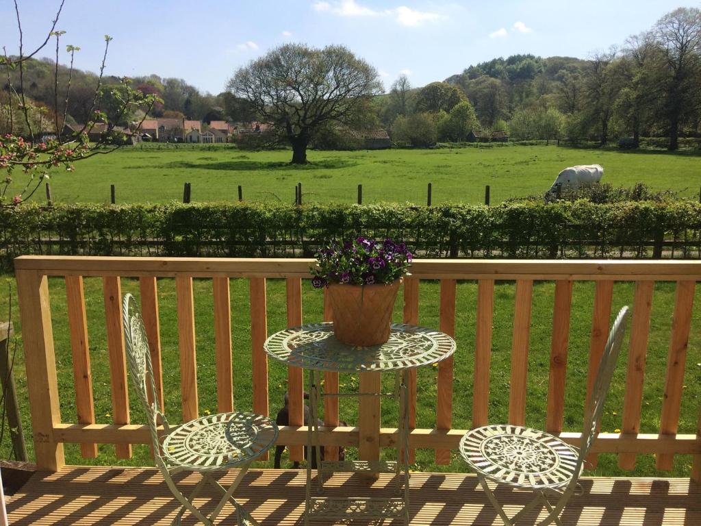 a table with a potted plant on it next to a bench at The Parcel Shed in Gilling East