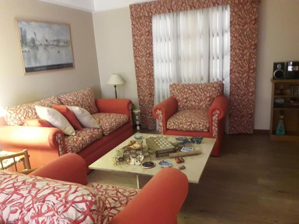 sala de estar con sofá, 2 sillas y mesa en Hermosa Casa Cerca de Todo en Rosario