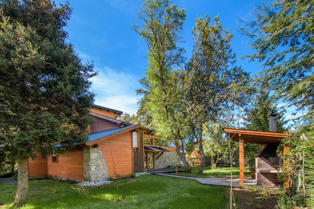 una casa con un patio con árboles en Casa Las Lilas en Villa La Angostura