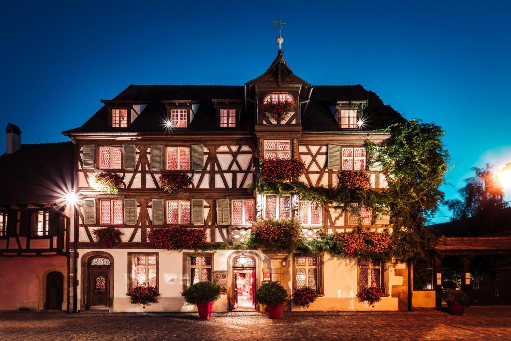 um grande edifício com flores ao lado em Hôtel des Deux Clefs em Turckheim