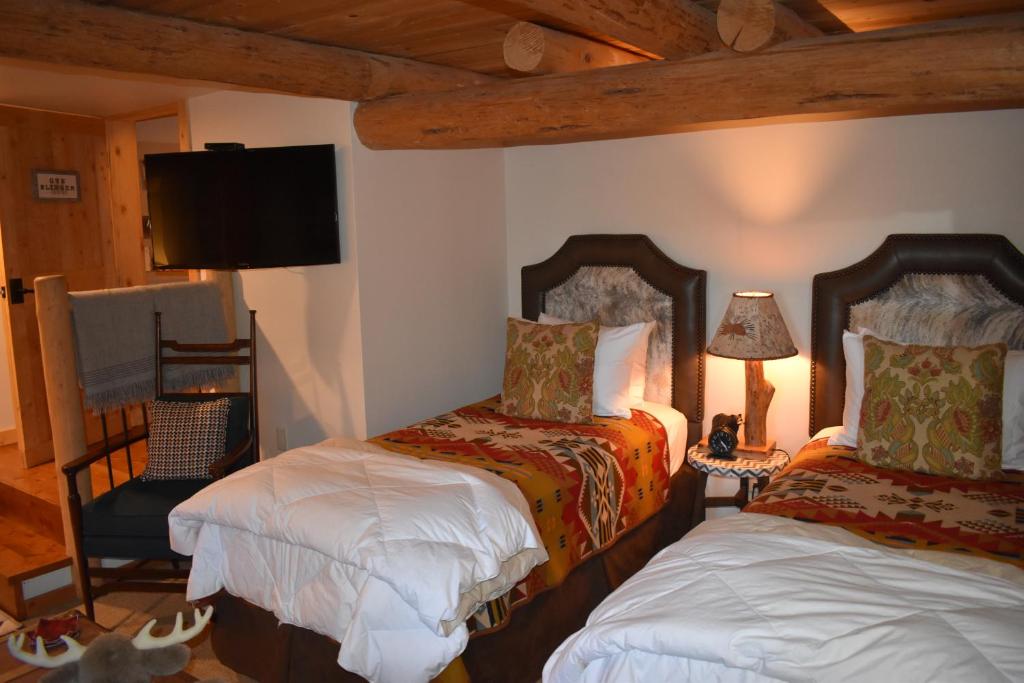a bedroom with two beds and a tv on the wall at Jackson Hole Hideout in Wilson