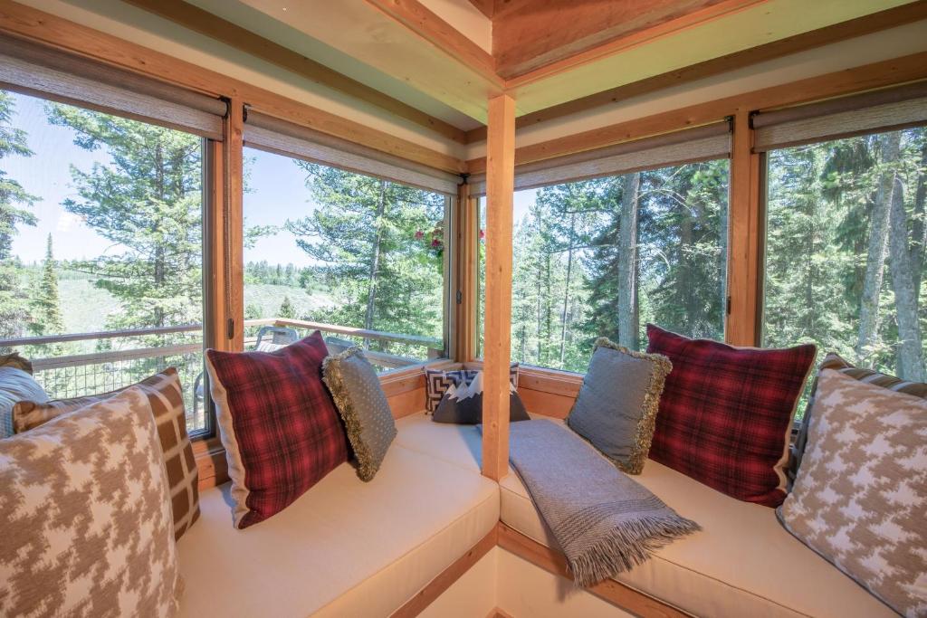 a room with two couches in front of windows at Jackson Hole Hideout in Wilson