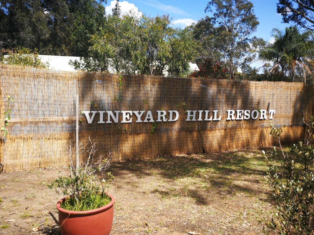 Un cartello che dice "Vineyard Hill Resort" su un muro di mattoni. di Vineyard Hill a Lovedale