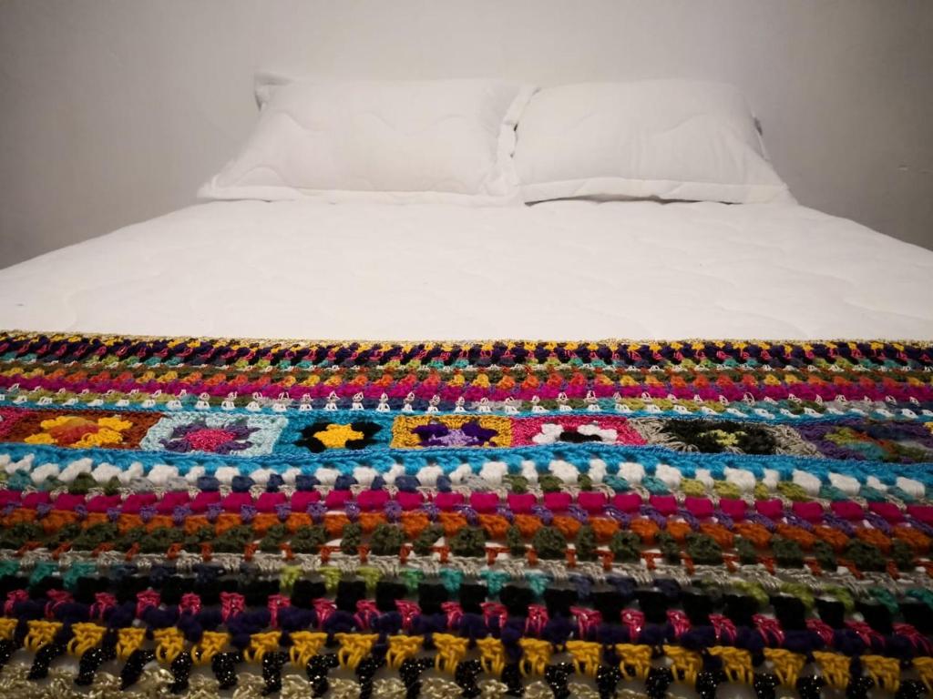a bed with colorful beads on it at Hotel Salento 1842 in Salento