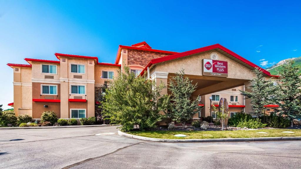 a front view of a hotel with a parking lot at Best Western Plus Canyon Pines in Ogden