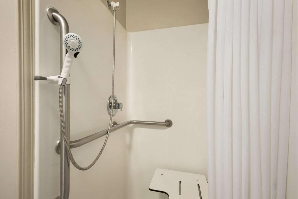 a shower in a bathroom with a hair dryer at Travelodge by Wyndham Missouri Valley in Missouri Valley