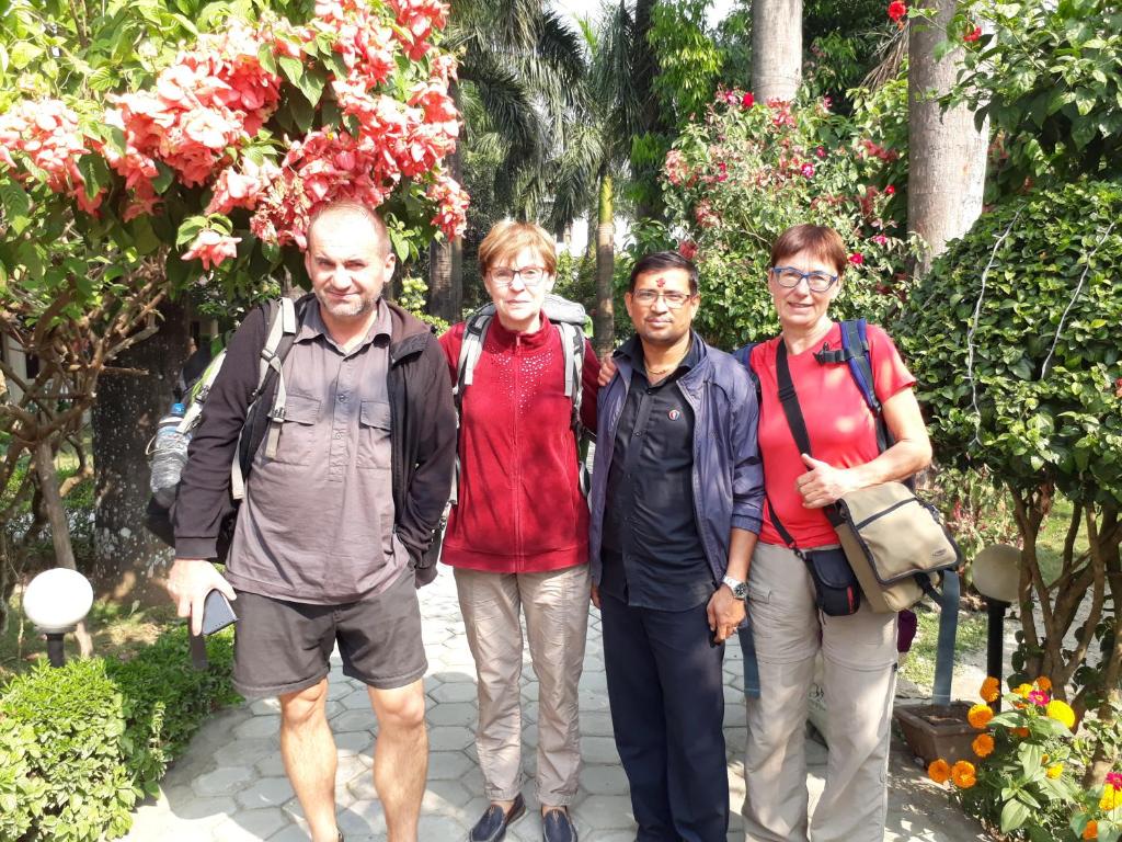 a group of people standing in a garden at Sauraha Resort in Sauraha