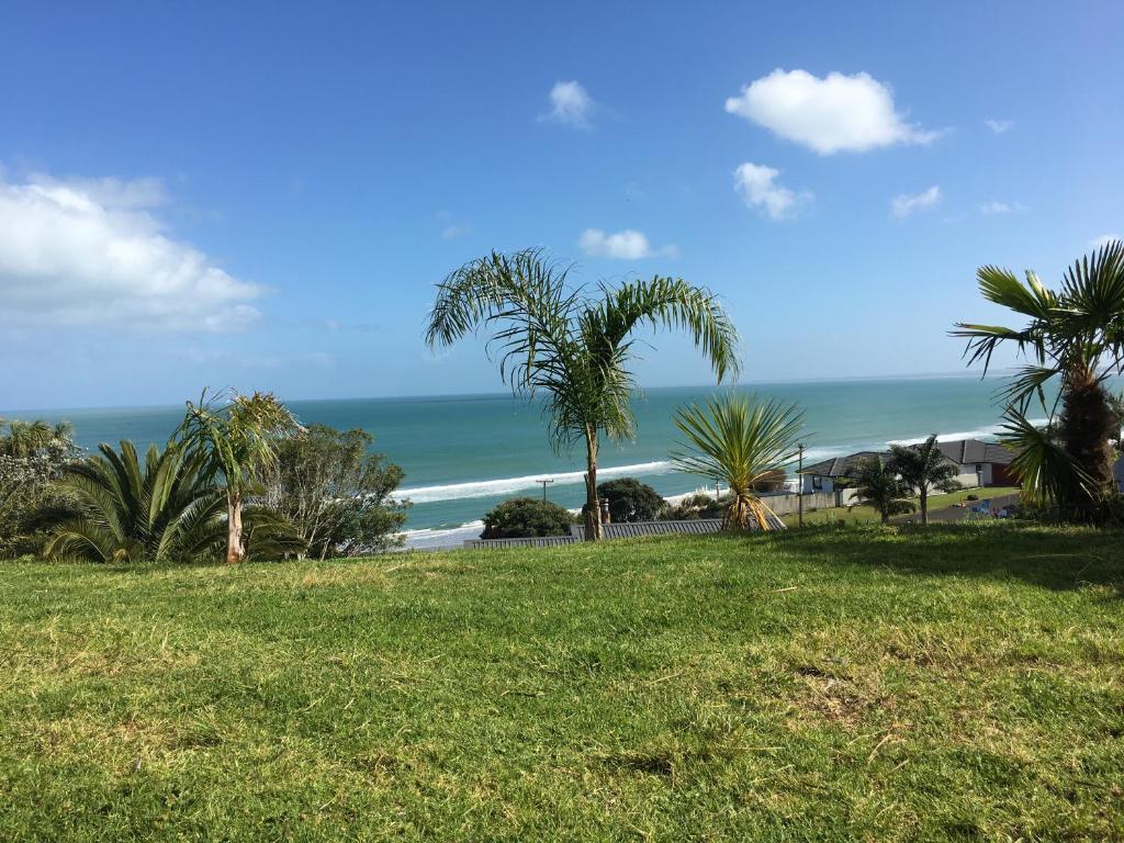 uma vista para uma praia com palmeiras e para o oceano em 90 Mile Paradise Ahipara em Ahipara