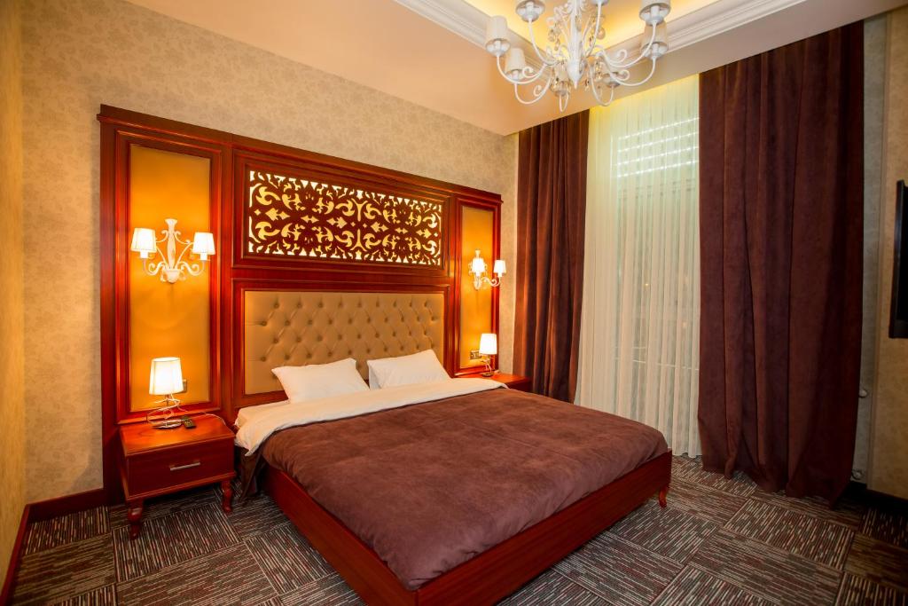 Un dormitorio con una cama grande y una lámpara de araña. en AZPETROL HOTEL MINGECHAUR, en Mingachevir
