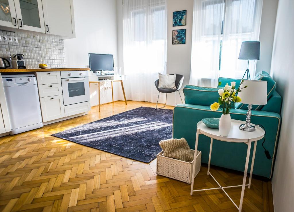 a living room with a green couch and a table at Ybl Apartment City Center in Székesfehérvár