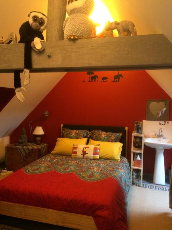 - une chambre dotée d'un lit avec un mur rouge dans l'établissement Le petit secret, à Saint-Aignan