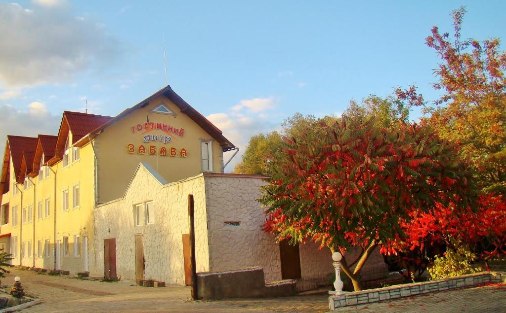 ein gelbes Gebäude mit einem Schild an der Seite in der Unterkunft Zabava Guest House in Iwano-Frankiwsk