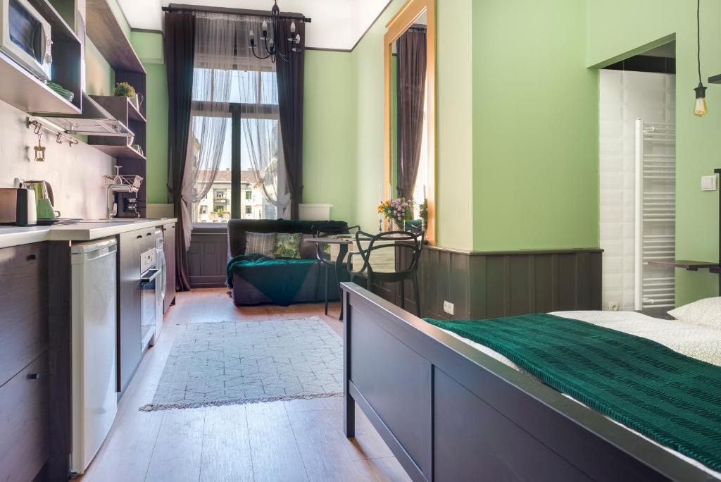 ブダペストにあるThe Green - elegant studio apartment in the center of Budapestの緑の壁のキッチン、ベッド1台が備わります。