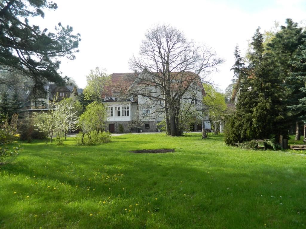 ヴェルニゲローデにあるペンション ハウス マルガの広い白家のある広い芝生の庭