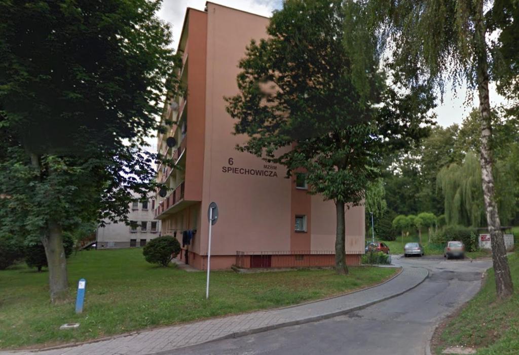 un grand bâtiment rose sur le côté d'une rue dans l'établissement Kwadrat B&B Spiechowicza, à Rzeszów