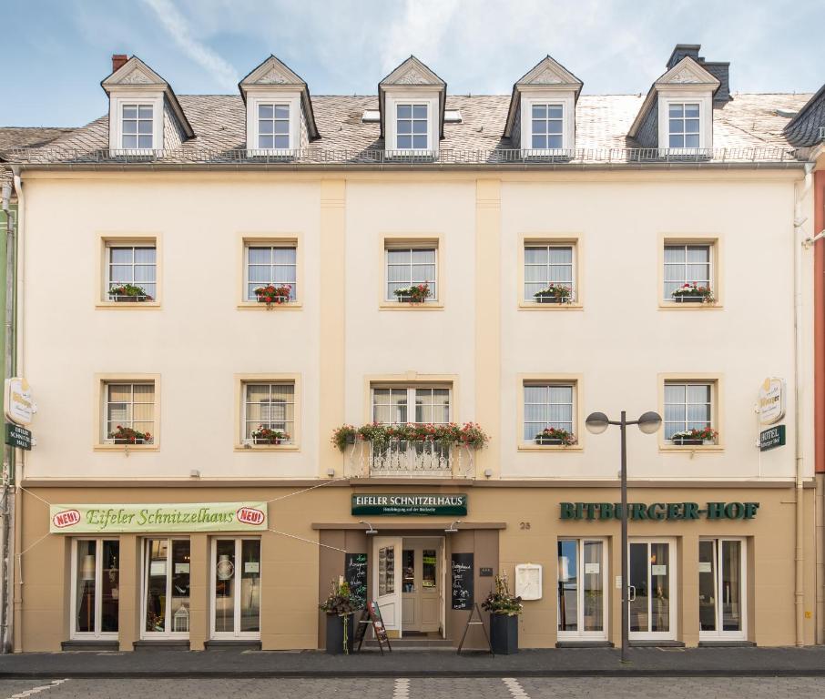 een groot crèmekleurig gebouw met ramen bij Hotel Bitburger Hof in Bitburg