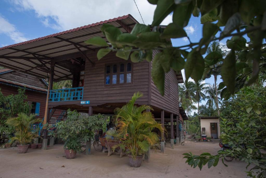 um edifício de madeira com plantas à sua frente em Chansor Community Homestay 6 em Phumĭ Trach Pôk (2)