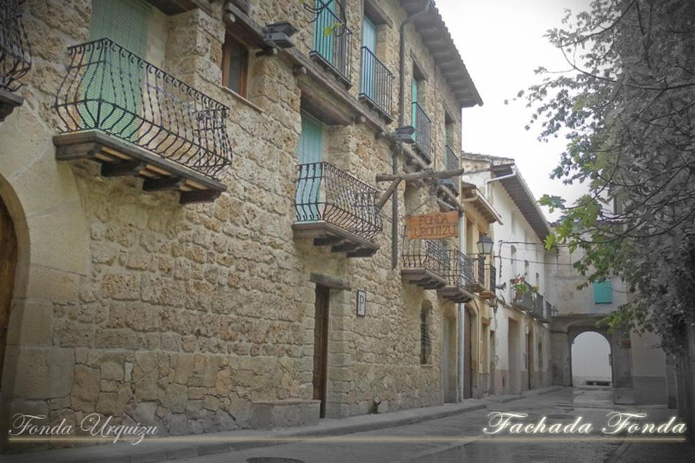 un edificio de piedra con balcones en el lateral de una calle en Fonda Urquizu, en Beceite