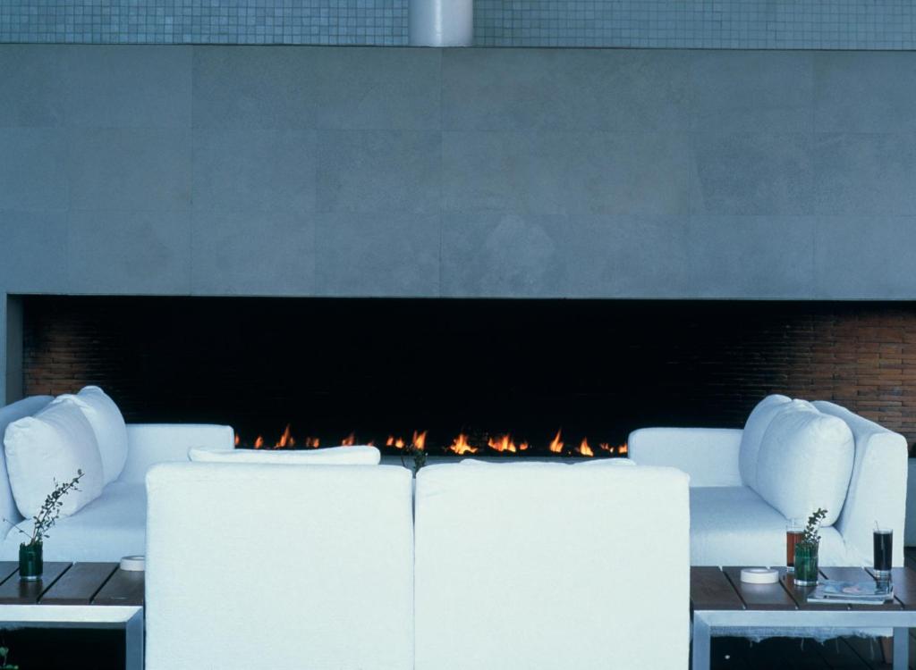 a living room with a fireplace with white furniture at Habita, Mexico City, a Member of Design Hotels in Mexico City