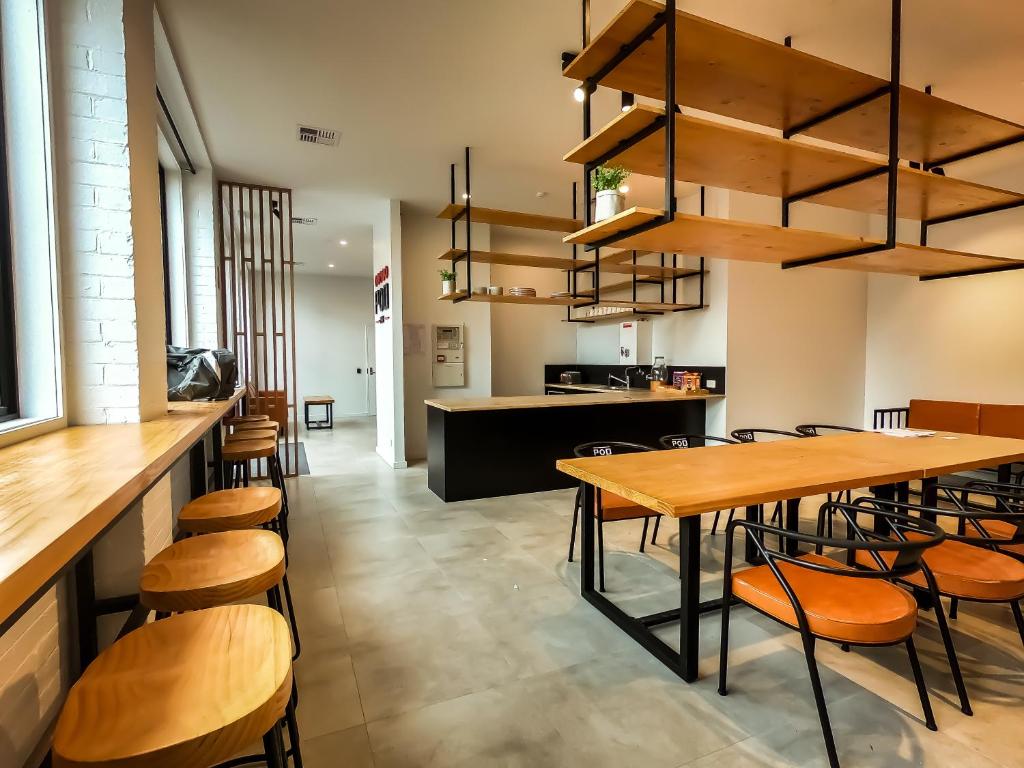 a kitchen filled with wooden tables and chairs at Pod Inn in Launceston