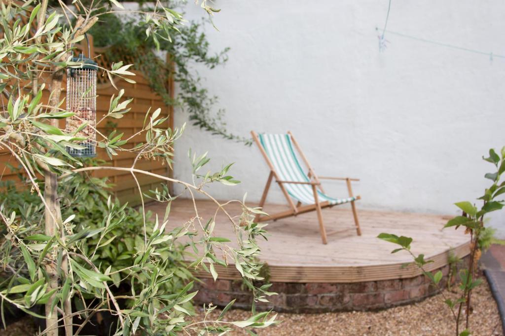 リバプールにあるThe Green Houseの庭園内の木製の台に座るロッキングチェア