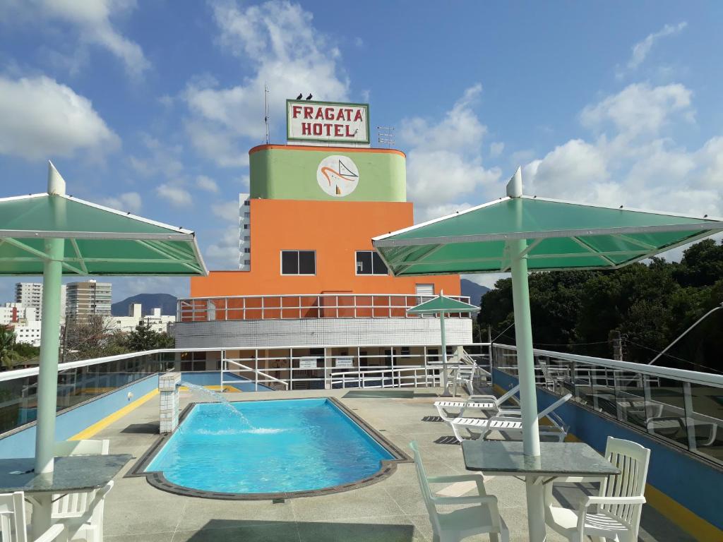 uma piscina num navio de cruzeiro com uma torre do relógio em Fragata Hotel em Guarapari